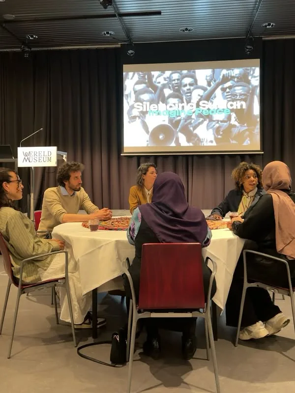 Foto van de avond van 15 april in Wereldmuseum Leiden: het panelgesprek en de zaal.