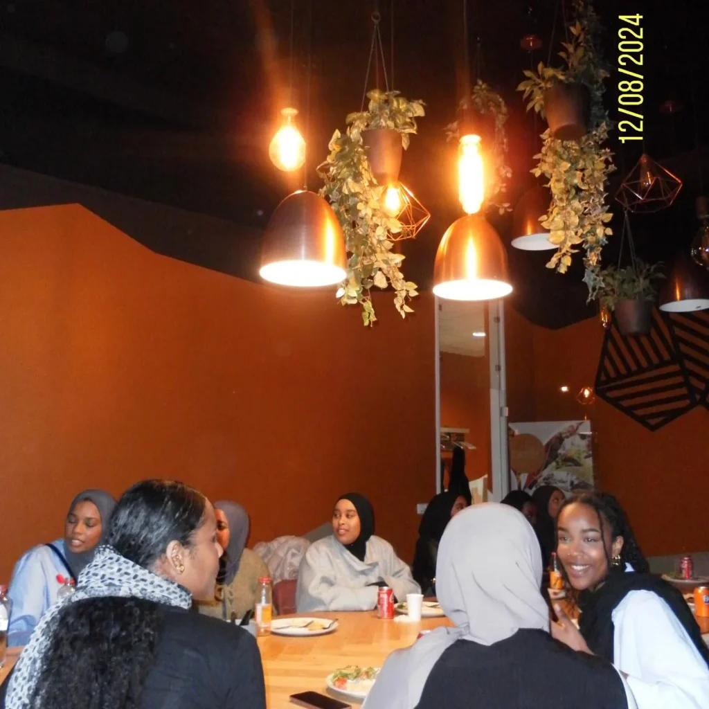 Bezoekers aan tafel tijdens de kennismakingsmiddag bij Napata Restaurant.